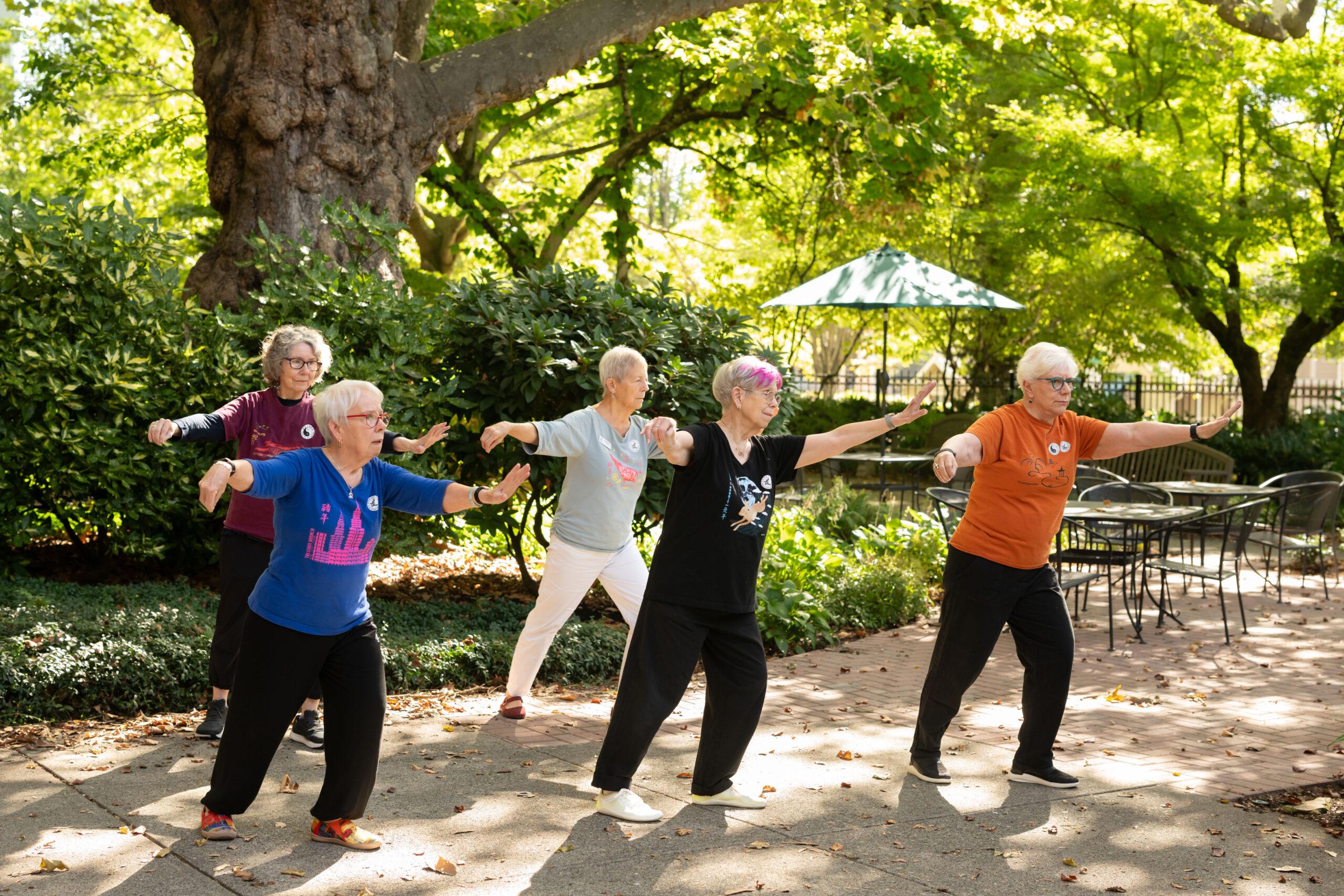 Holladay Park Plaza residents concentrate on doing yoga outdoors.