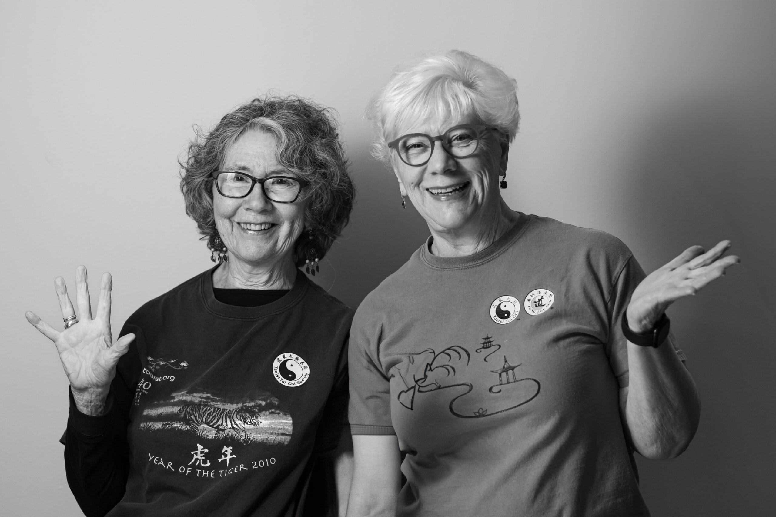 Black and white portrait of two friendly Holladay Park Plaza residents waving.