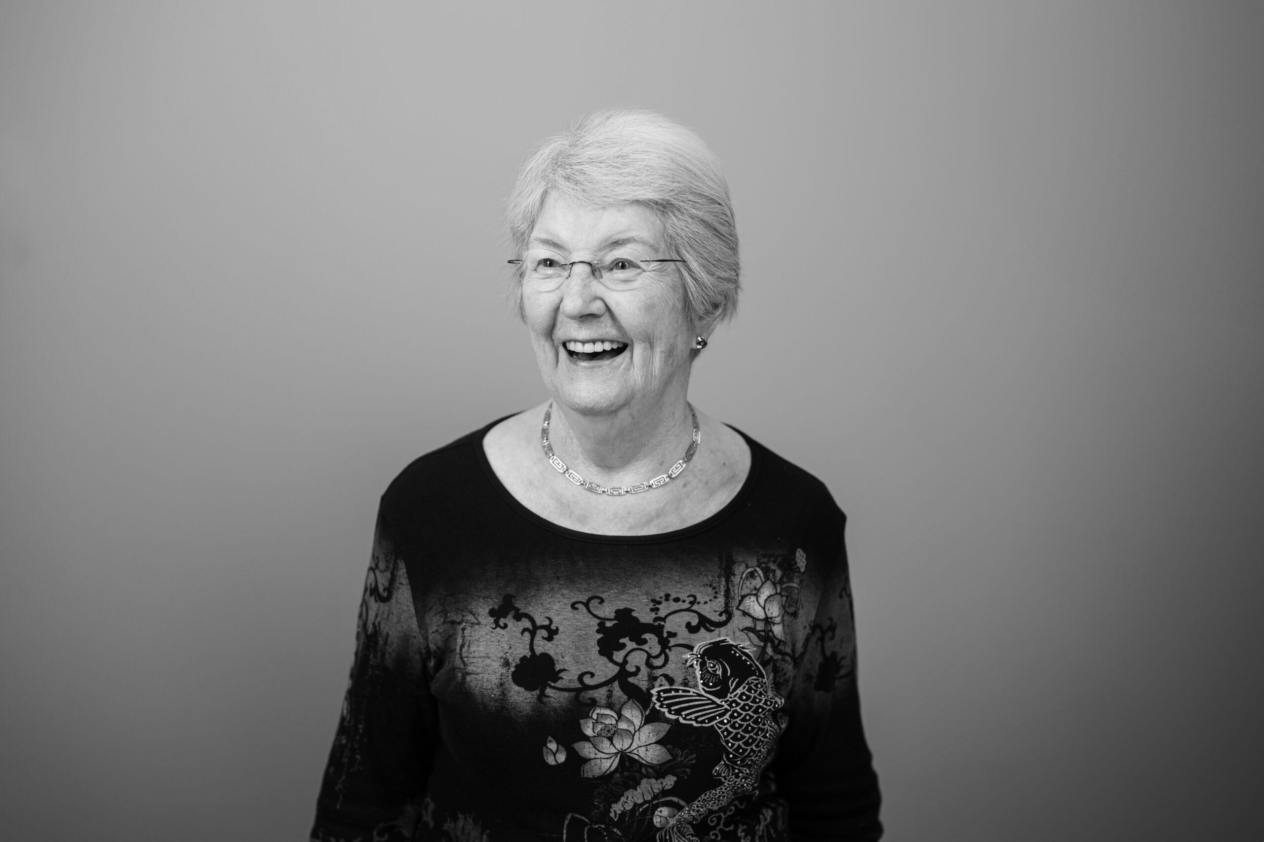 Black and white portrait of a Holladay Park Plaza resident smiling and looking away from the camera.