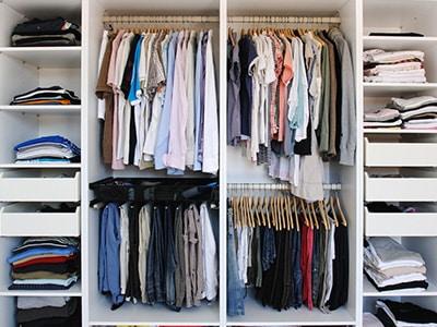 A well-organized closet space with several areas for hanging clothes, folding clothes, and putting clothes in drawers.