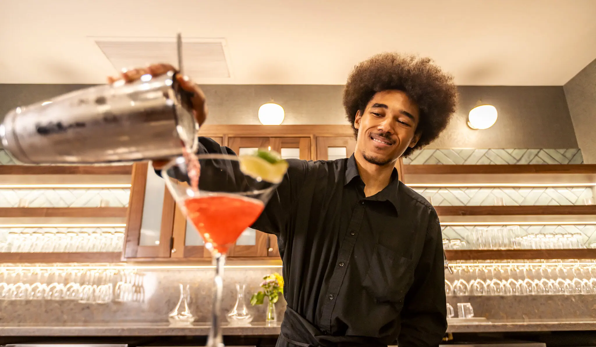 Close-up shot of a cocktail being poured by a mixologist.
